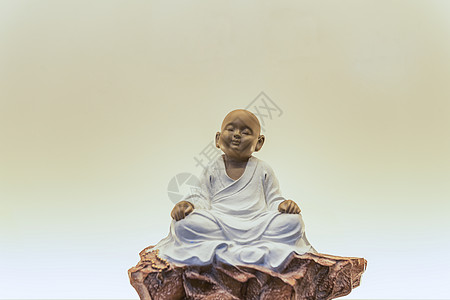 佛教雕塑打坐的小和尚背景