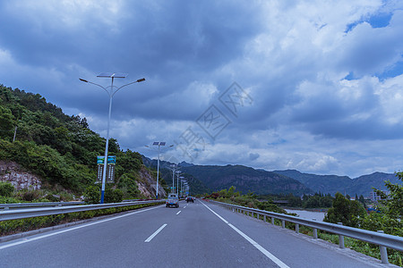 多云天气大气宽广依山公路背景图片