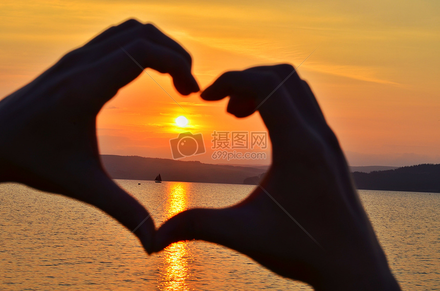 高清照片下载,该高清照片标题为夕阳下情侣爱心手势唯美爱情,编号