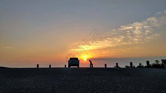 夕阳下的车和人背景图片