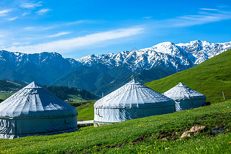 蓝天白云绿草地新疆的雪上和蒙古包背景