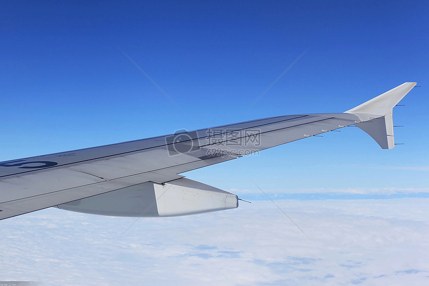 飞行在蓝天中的客机机翼图片