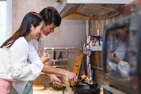 亚洲男人一起烹饪的情侣背景
