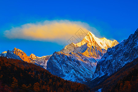 夏诺多吉雪山的日照金山和飘动的云图片