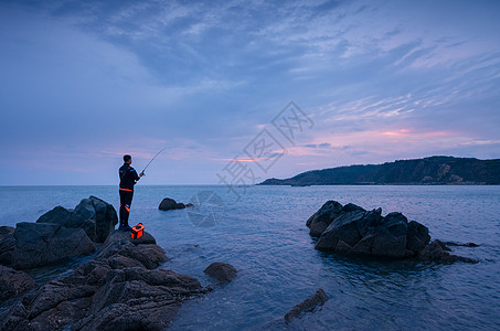 海边钓鱼人海水与礁石高清图片