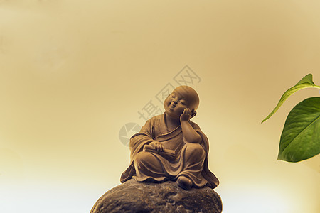 佛教雕塑打坐的小和尚背景