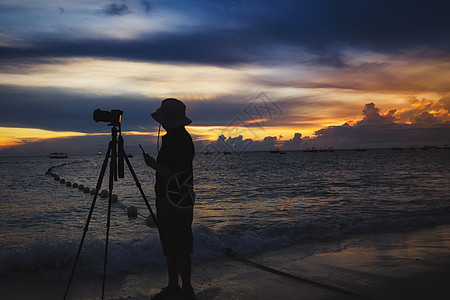 夕阳海滩海边的摄影师背景