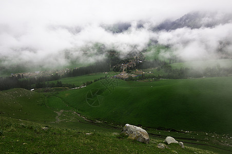 新疆特克斯云雾草原山坡背景图片