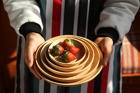 草莓圆手持圆木盘和草莓水果背景