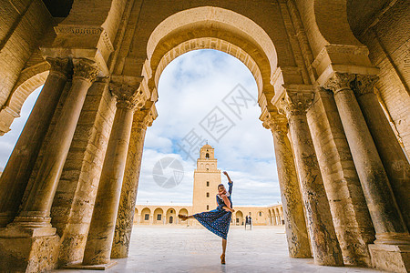 女性跳跃突尼斯凯鲁万奥克巴大清真寺里跳舞的女性背景