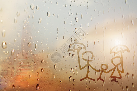 玻璃窗上雨滴的家庭背景图片