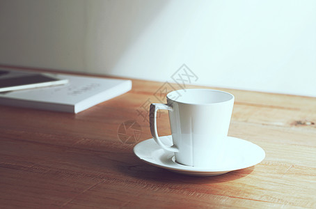 桌子木纹桌上的咖啡杯和杂志背景