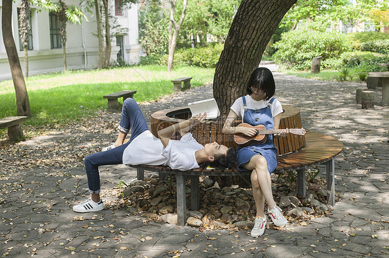 学校绿荫下男女同学在一起学音乐恋爱图片