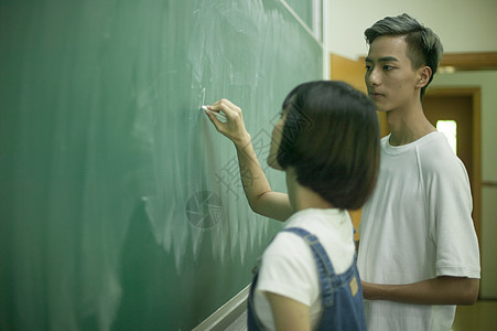 学校教室里学生在黑板前写字图片