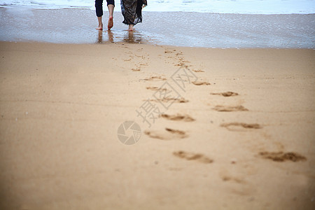 一对情侣在沙滩上行走背景图片