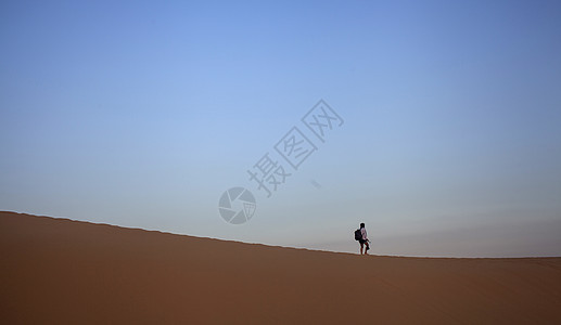 旅行中一个人孤独的在沙漠上行走背景图片