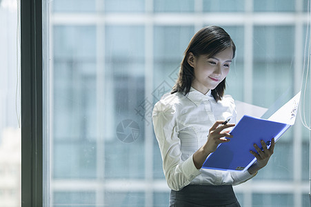 商务女性看文件办公室里商务女士在看文件背景