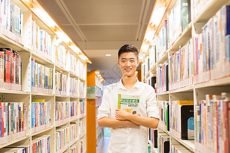 站在图书馆书架旁看书的帅气男同学图片