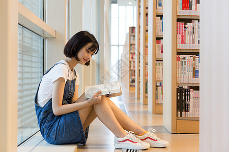 少年学生在图书馆里看书的女生背景