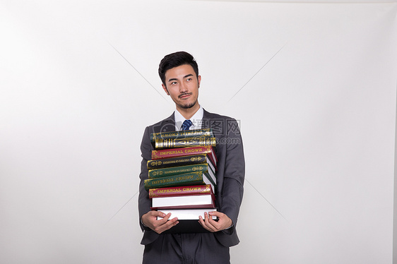 抱着一大堆书的商务人士图片