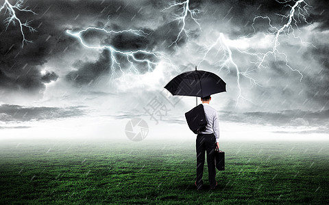 打伞商务男士打伞商务人站在打雷下雨的草坪上设计图片