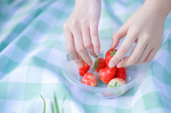 野餐拿草莓的双手图片