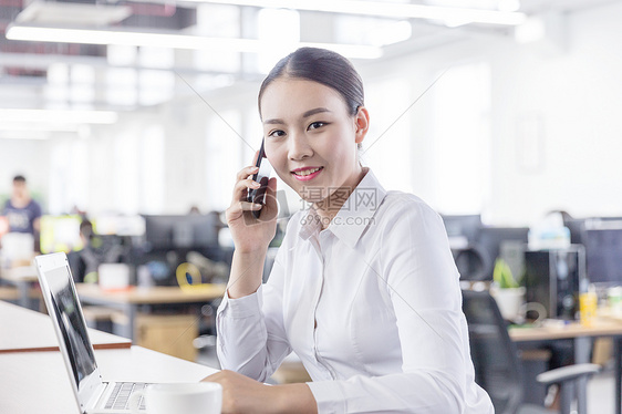 开放区域办公打电话的白领女性图片