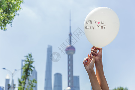 女上海情侣手举求婚气球素材背景