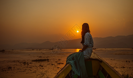 缅甸女孩湖上欣赏日落的女孩背景