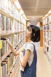 年轻女大学女生图书馆书架找书背景