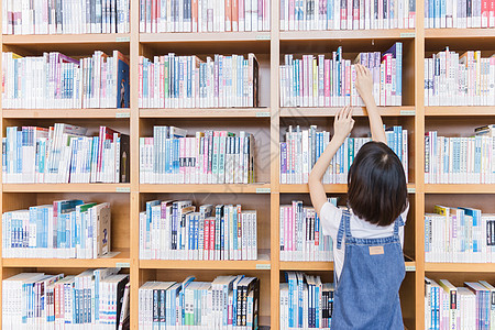 大学女生图书馆书架找书背景图片