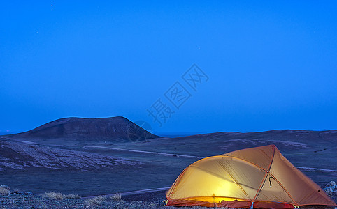 夜晚登山火山草原下露营背景