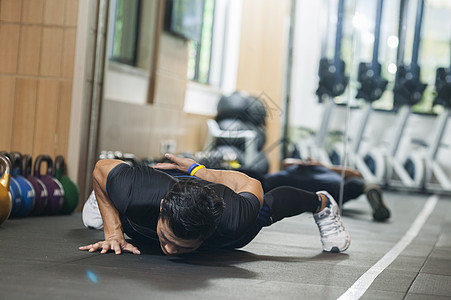 单臂俯卧撑男性在健身房里健身背景