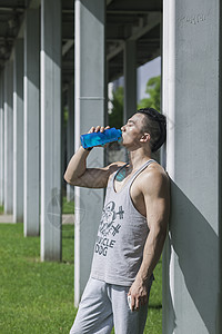 男孩在户外运动后喝运动饮料图片