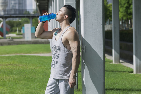 男孩在户外运动后喝运动饮料图片