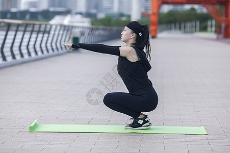 女性在户外瑜伽垫上锻炼形体图片素材