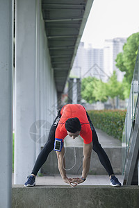 男性在户外运动场所做热身运动准备图片