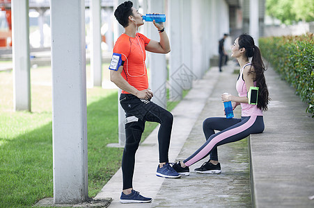 男女组合年轻男女在户外锻炼后休息喝水背景