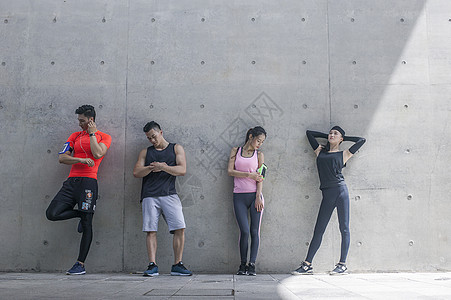 年轻男女在户外运动场所热身运动图片