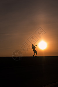 夕阳下男孩和太阳在做游戏背景图片