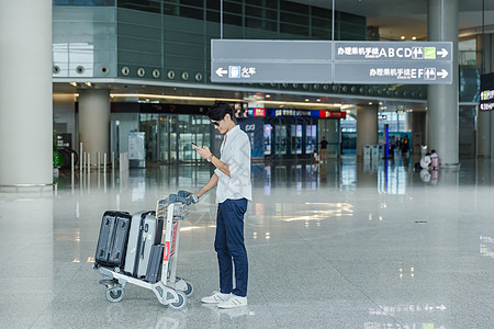 节日旅游出行男人候机看手机图片