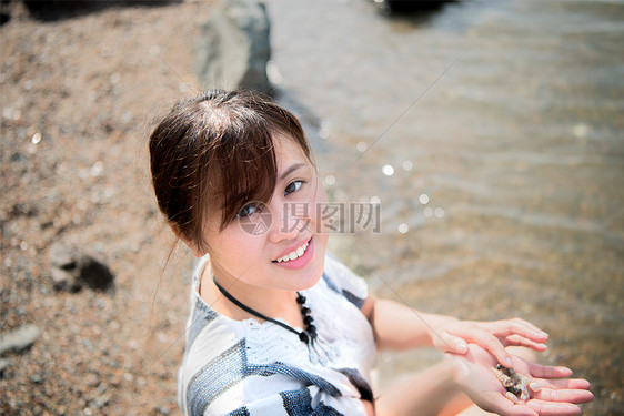 清晨海边捧水的美少女图片