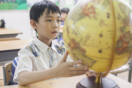 教室里男同学正在研究地球仪图片