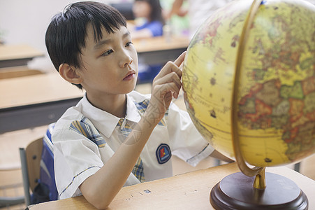 少年奔跑教室里男同学正在研究地球仪背景