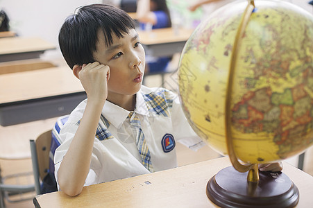 教室里男同学正在研究地球仪图片