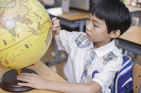教室里男同学正在研究地球仪图片
