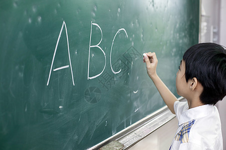 小学生拿黑板英语课上男同学在写黑板背景