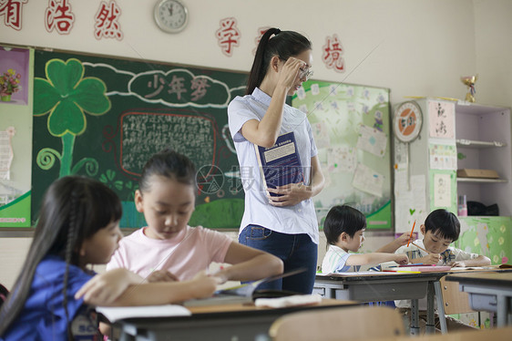 上课时老师在辅导学生认真学习图片