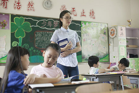 上课时老师在辅导学生认真学习图片