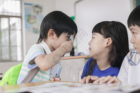 小学生同学在教室里一起研究学习背景图片